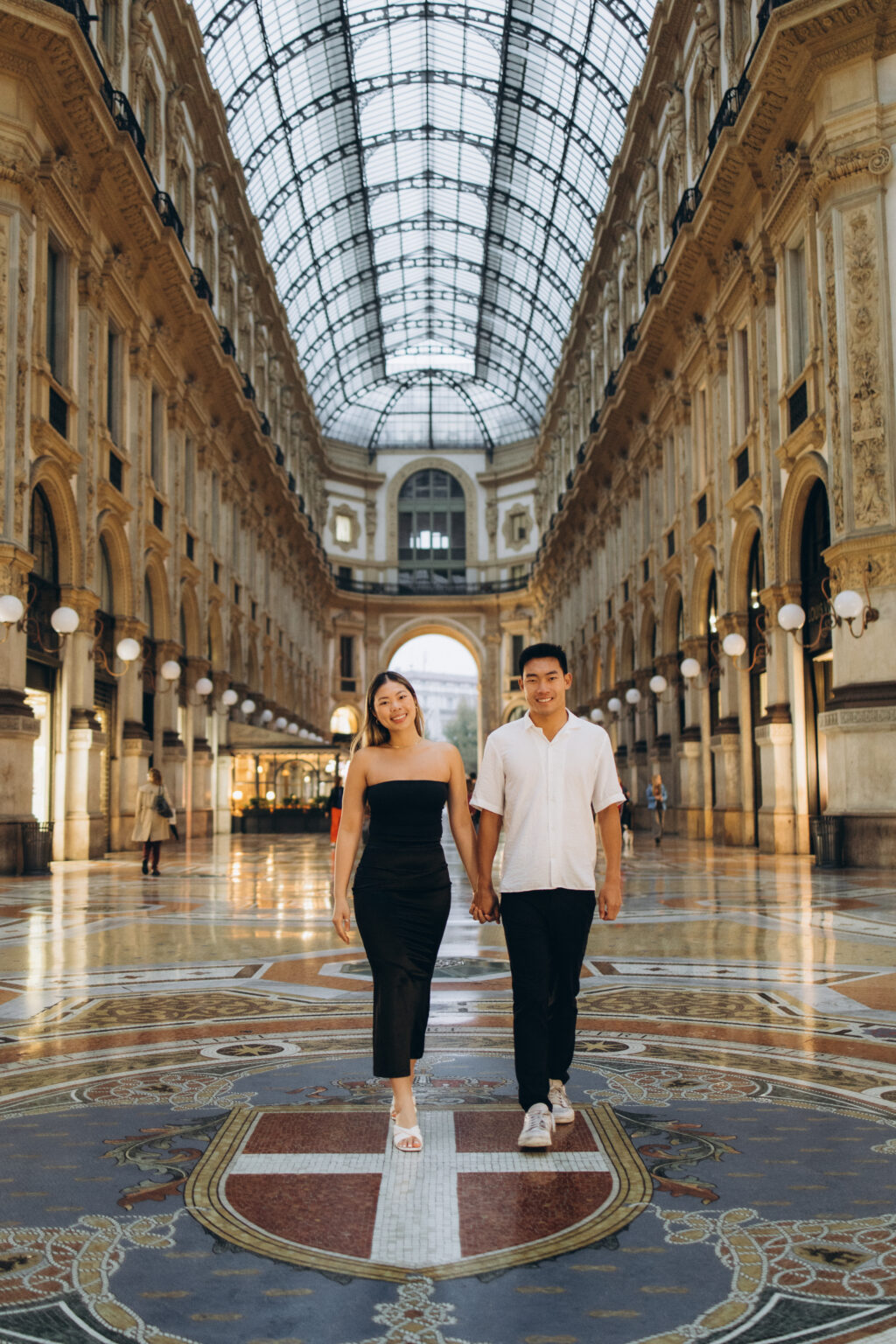 Couple holding hands on the mosaic floor of Galleria Vittorio Emanuele II during a couples photoshoot in Milan