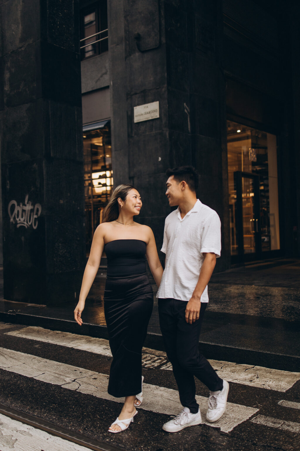 Stylish couple crossing a street in Milan's fashion district, photographed by a couple photographer in Milan