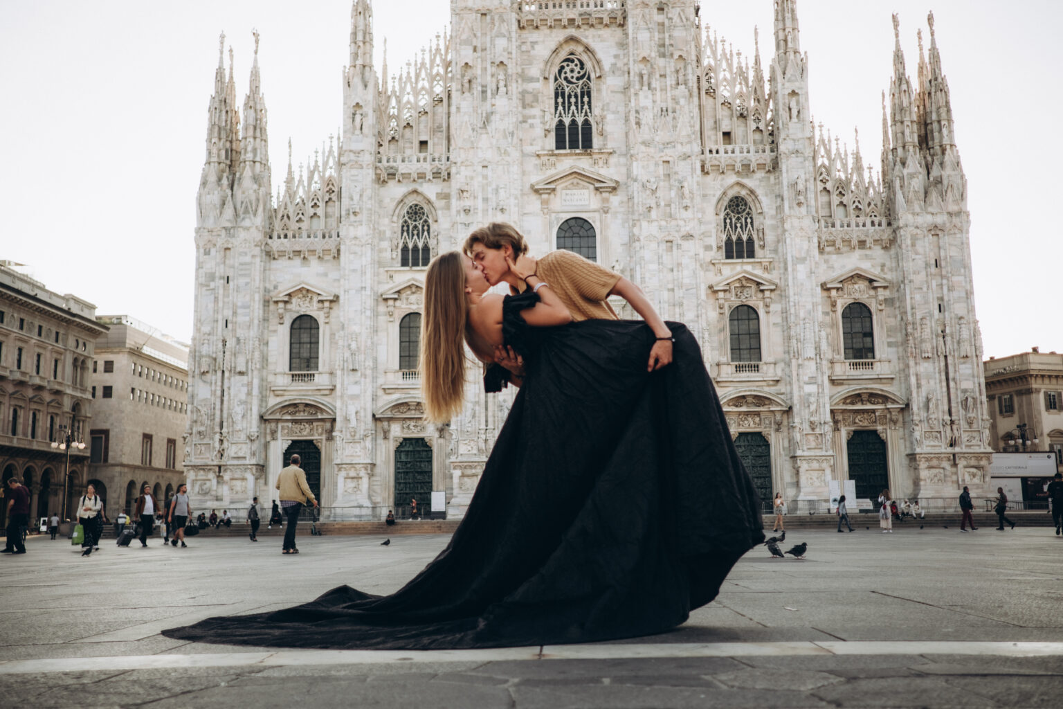 Couple in a dip kiss in front of Milan Cathedral during a couple photoshoot in Milan