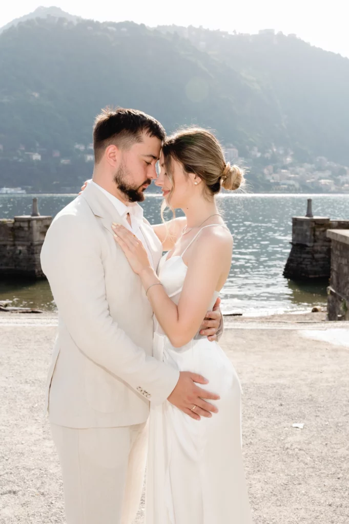 Bride and groom forehead to forehead on the Como lakefront on their wedding day