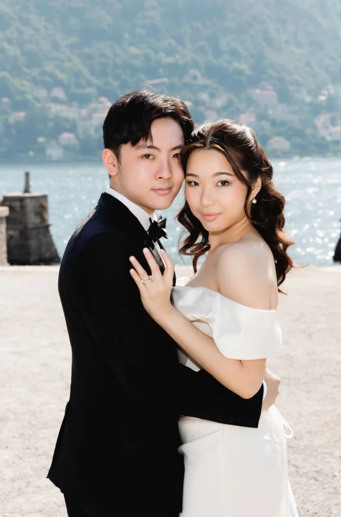 Bride and groom embracing on a lakefront in Bellagio