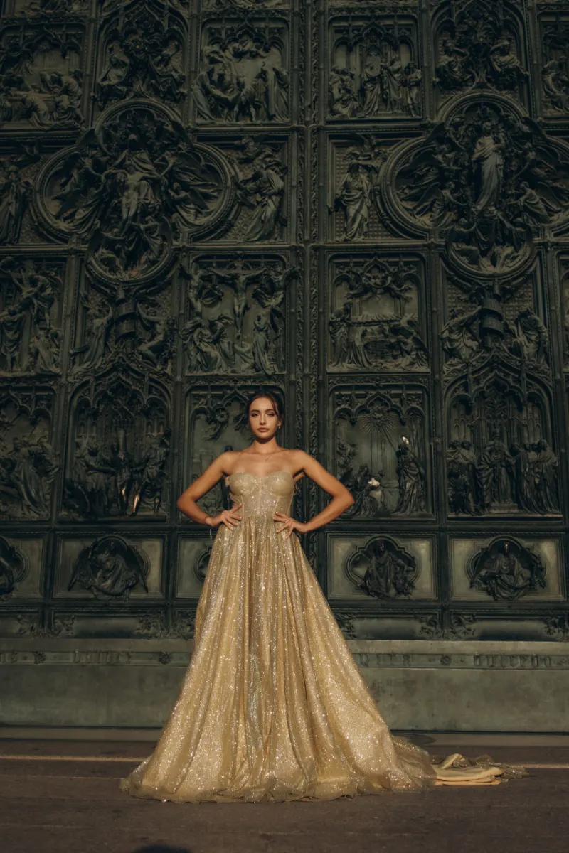 Woman in a champagne gown by a carved wooden door in Milan