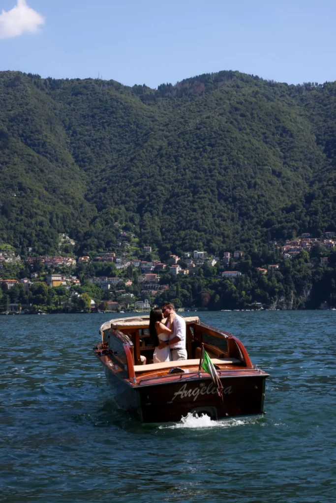 Couple kissing on a wooden boat sailing across Lake Como