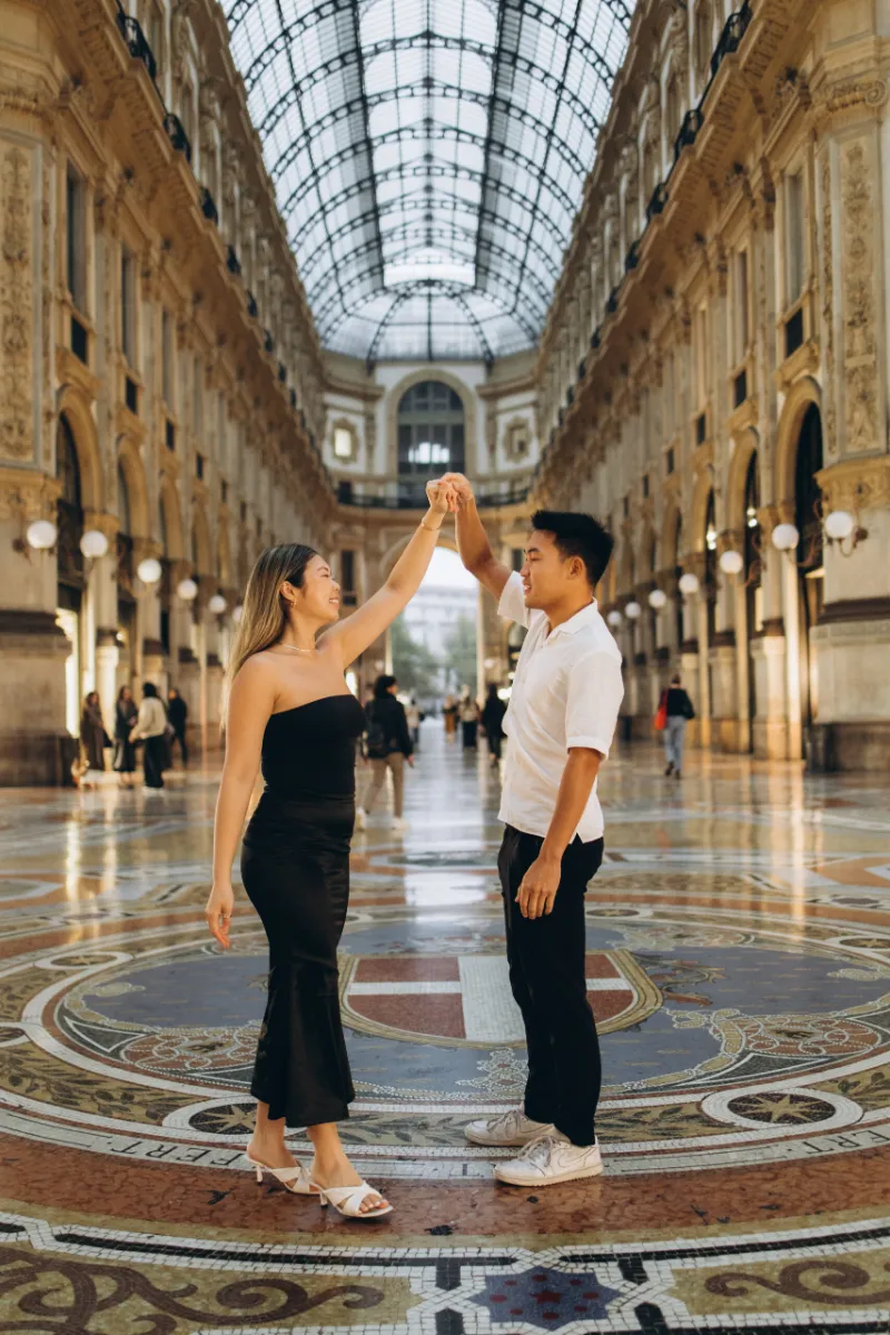 Couple walking under the glass dome of Galleria Vittorio Emanuele II, Milan