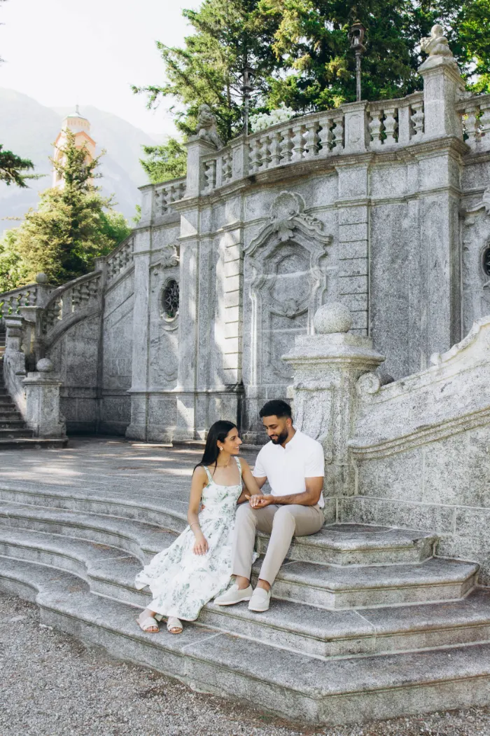Couple sitting on the stone steps by the bell tower in Tremezzo
