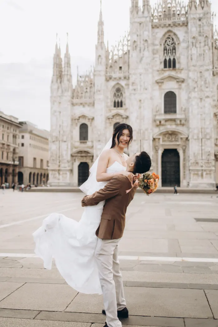 Groom lifting his bride in front of the Duomo