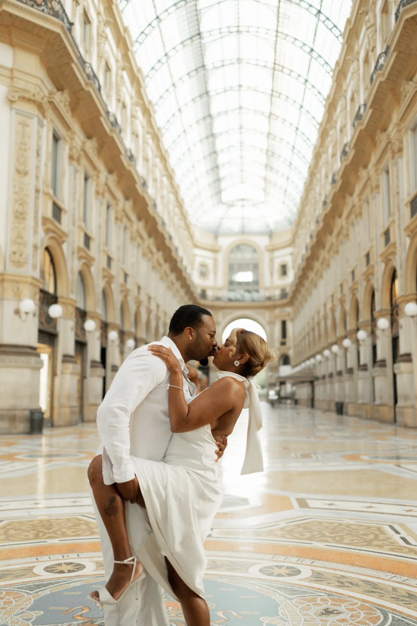 Couple kissing in the empty Galleria Vittorio Emanuele II early in the morning