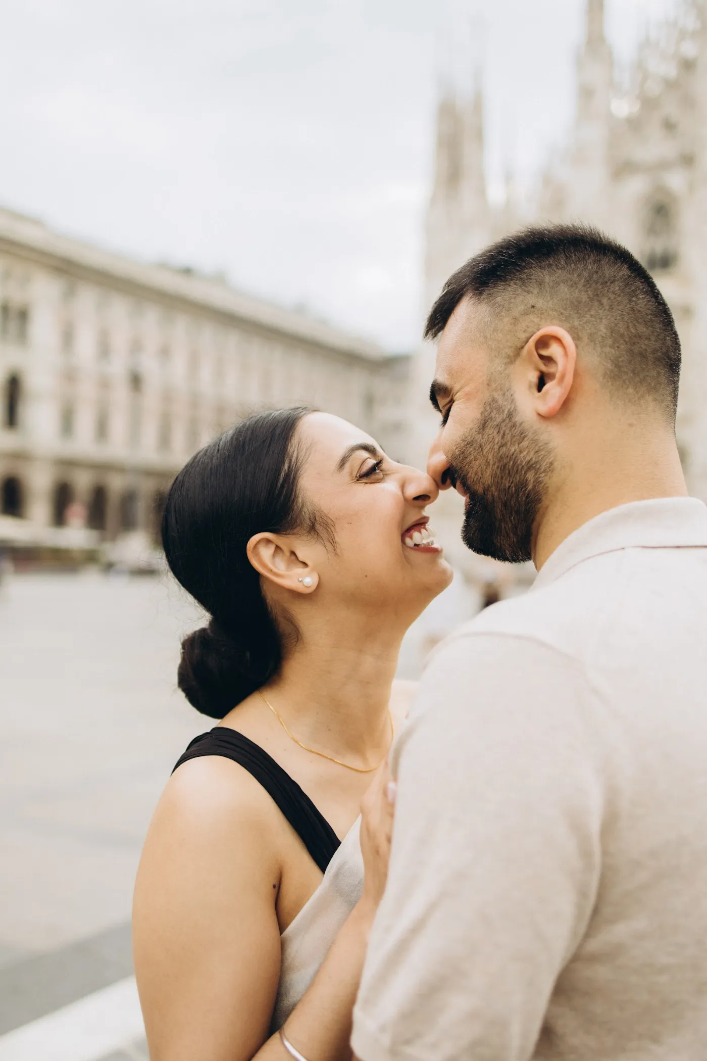 Woman laughing as her partner leans in, Piazza del Duomo, Milan