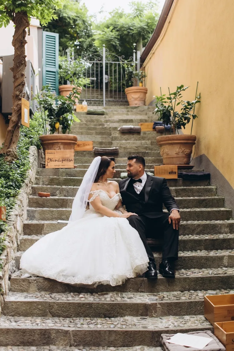 Bride and groom sitting on the flower-lined steps of a Bellagio lane