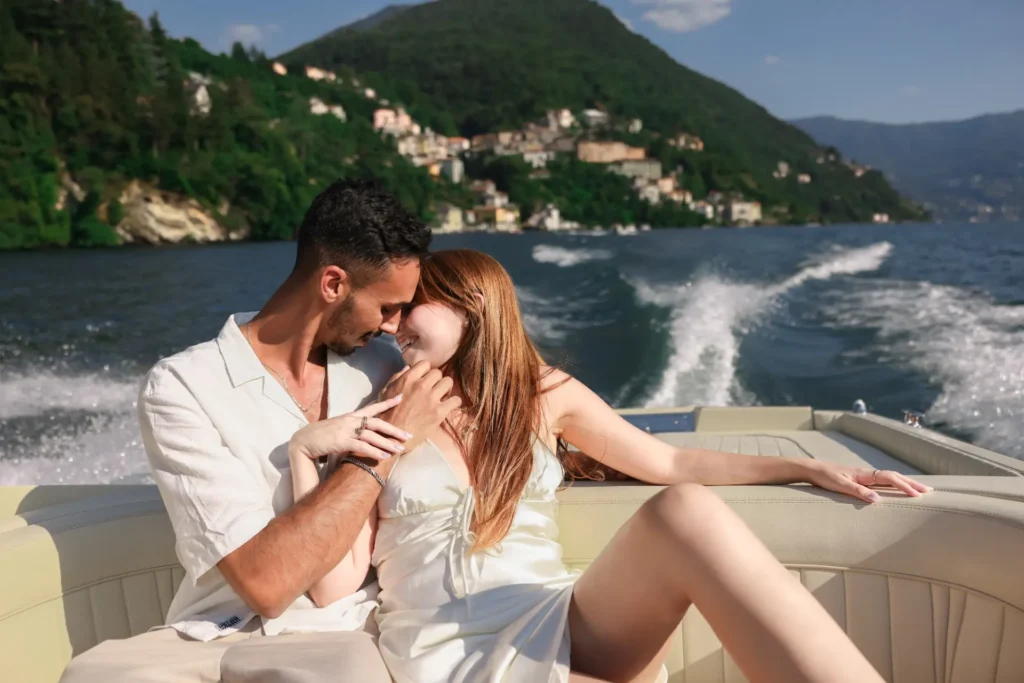 Couple laughing on a wooden boat on Lake Como