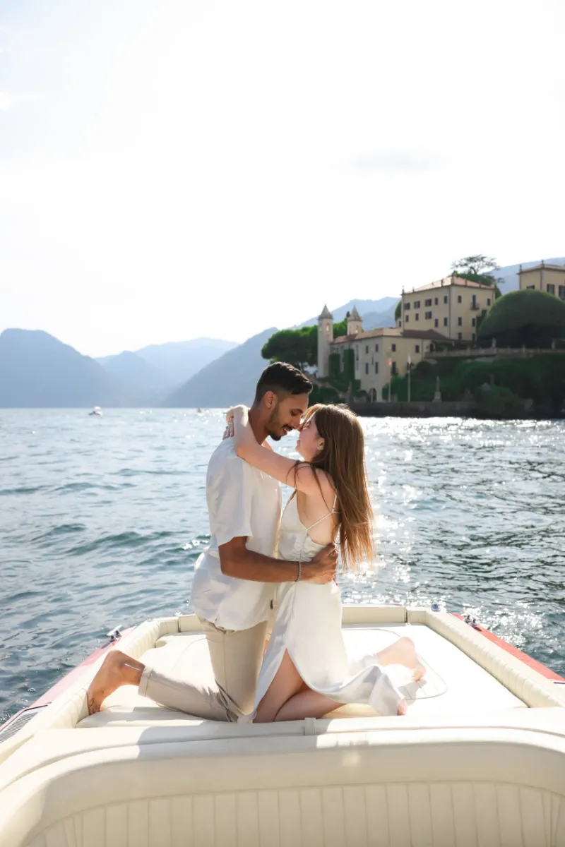 Couple on the bow of a boat in front of Villa del Balbianello, Lake Como