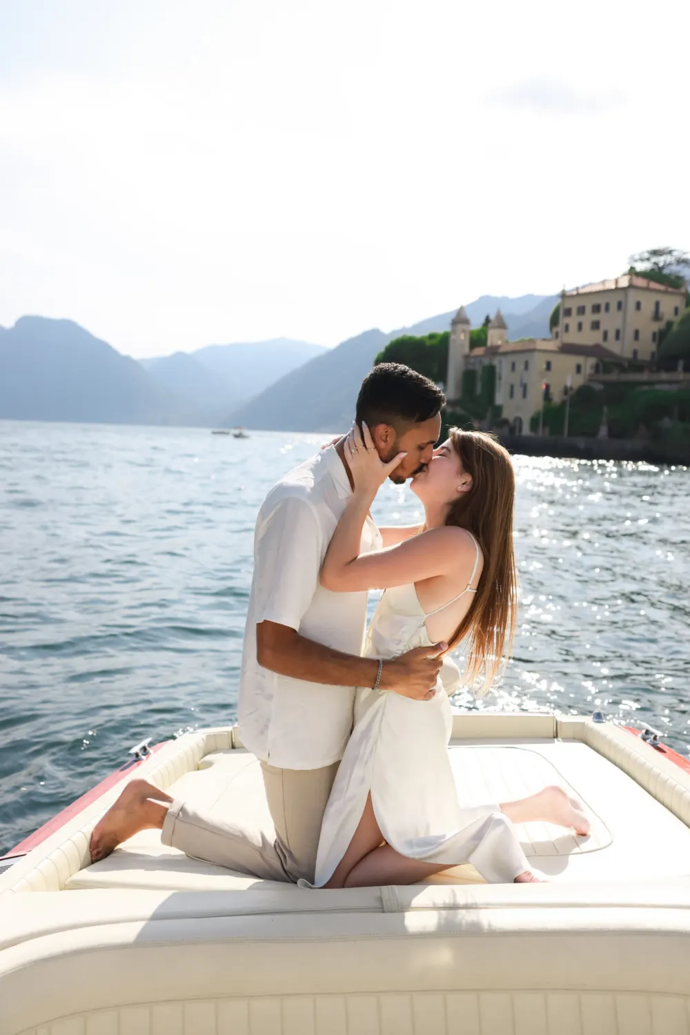 Couple kissing on a boat below Villa del Balbianello after a proposal