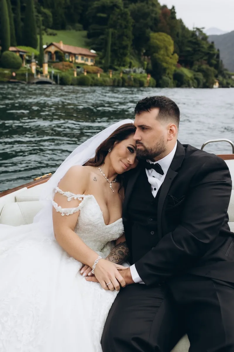 Bride resting her head on the groom’s shoulder on a boat, Lake Como
