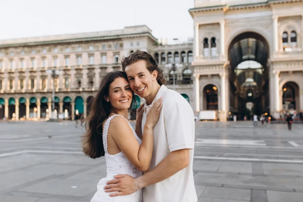 Couple smiling in Piazza del Duomo by the Galleria arch, Milan