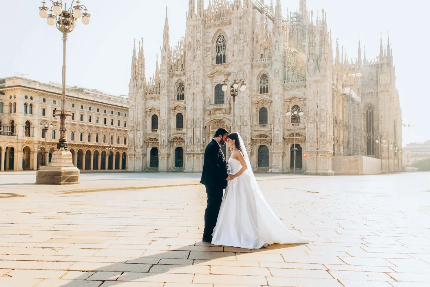 Bride and groom in the empty Piazza del Duomo at sunrise, Milan
