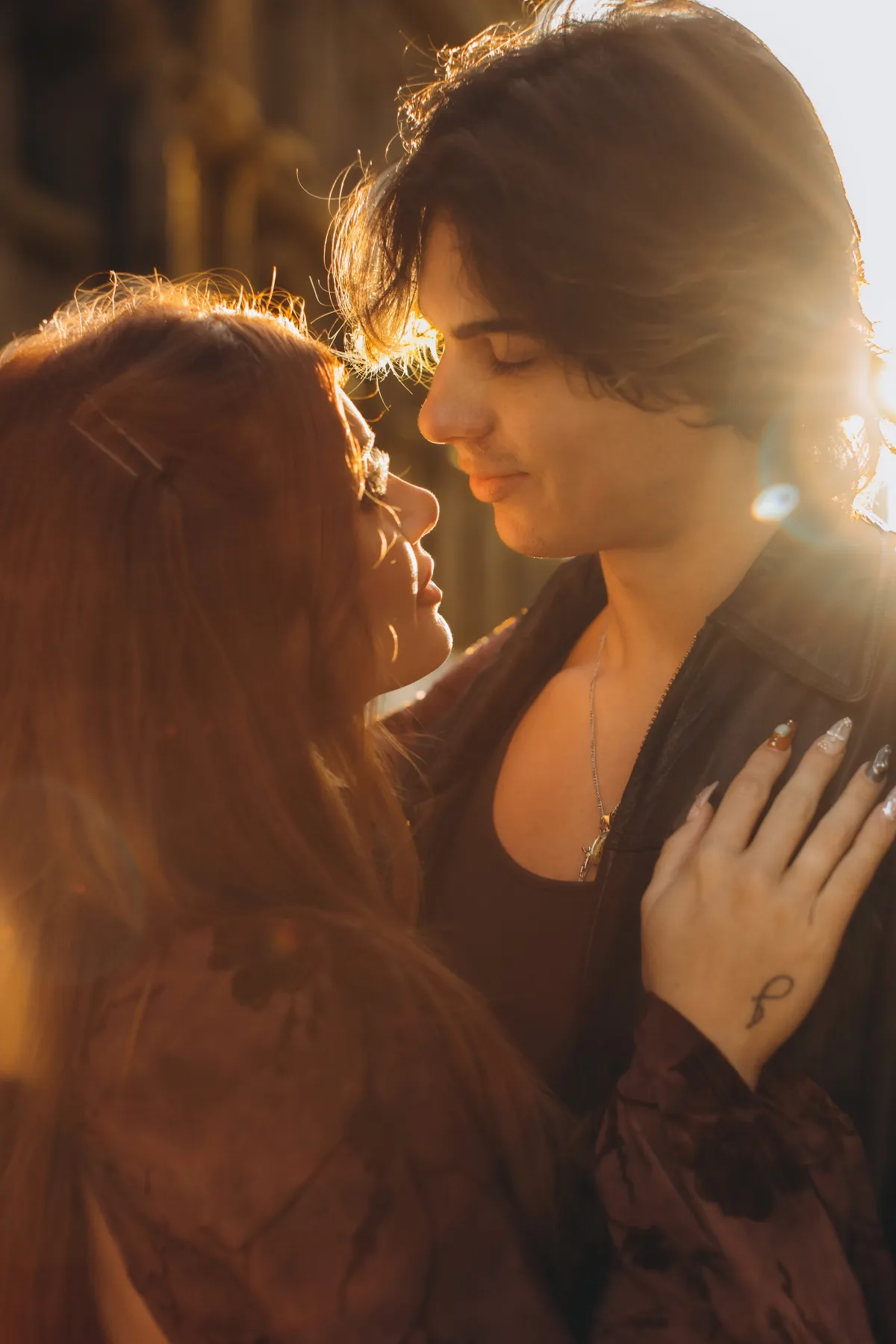 Engaged couple embracing in warm golden light in Milan