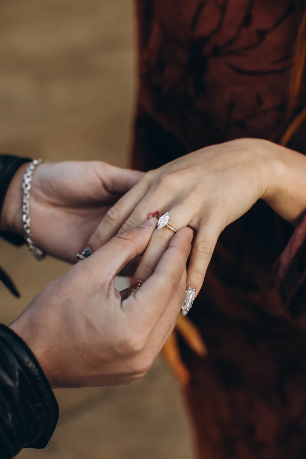 He slides the engagement ring onto her finger in Milan