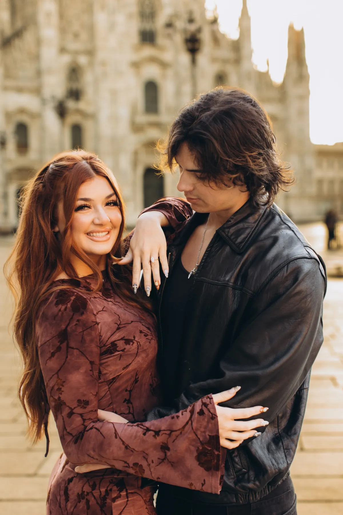 Newly engaged couple showing the ring in front of the Duomo in Milan