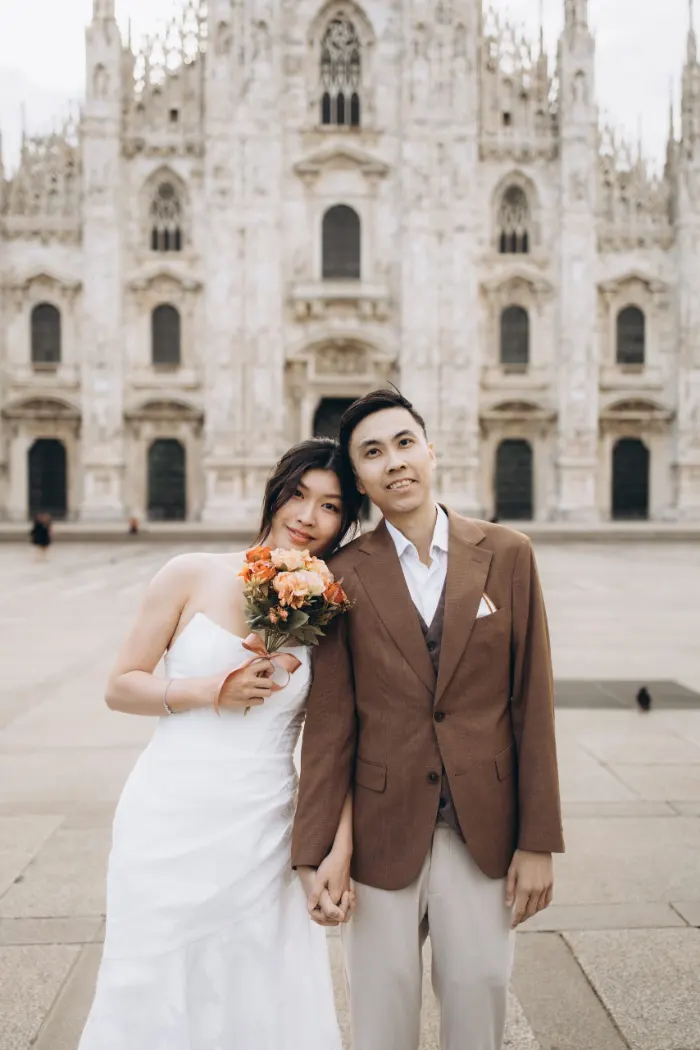 Bride and groom with her bouquet in front of the Duomo in Milan