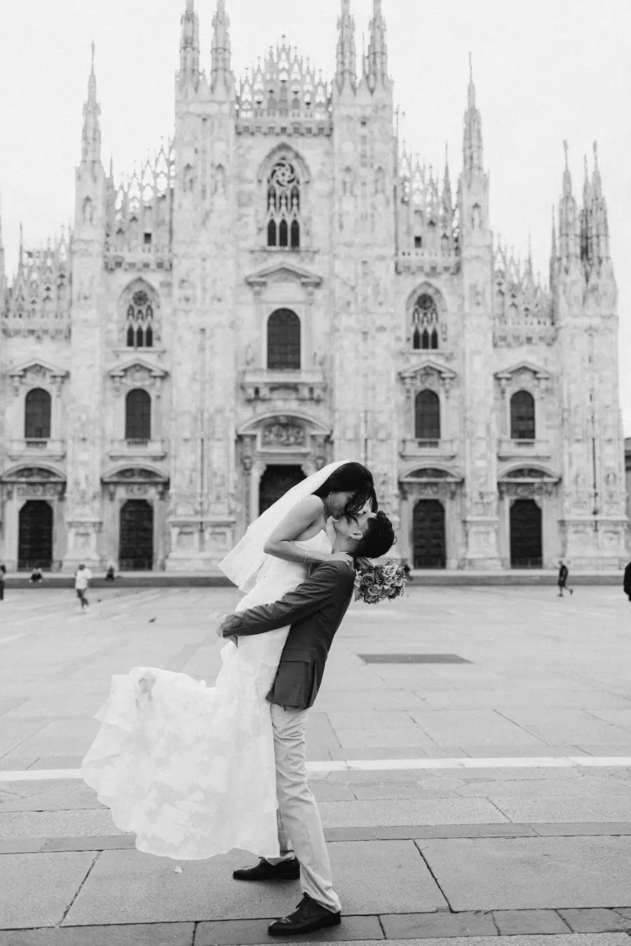 Bride and groom close together in front of the Duomo in Milan