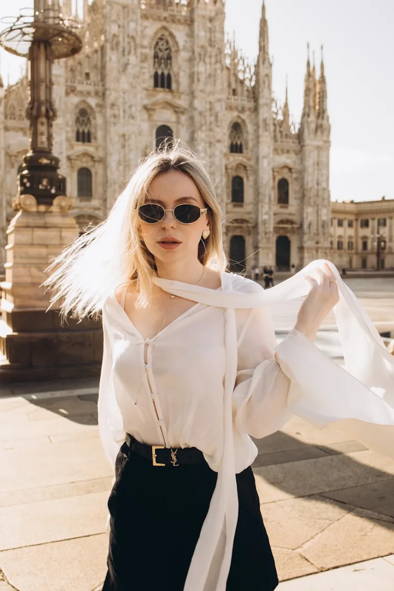 Woman in sunglasses with her hair in the wind on Piazza del Duomo, Milan