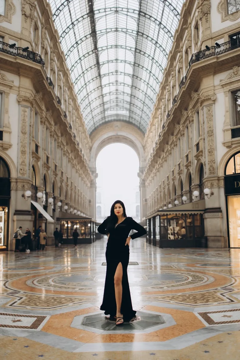 Woman in a black gown alone in the empty Galleria Vittorio Emanuele II at dawn, Milan