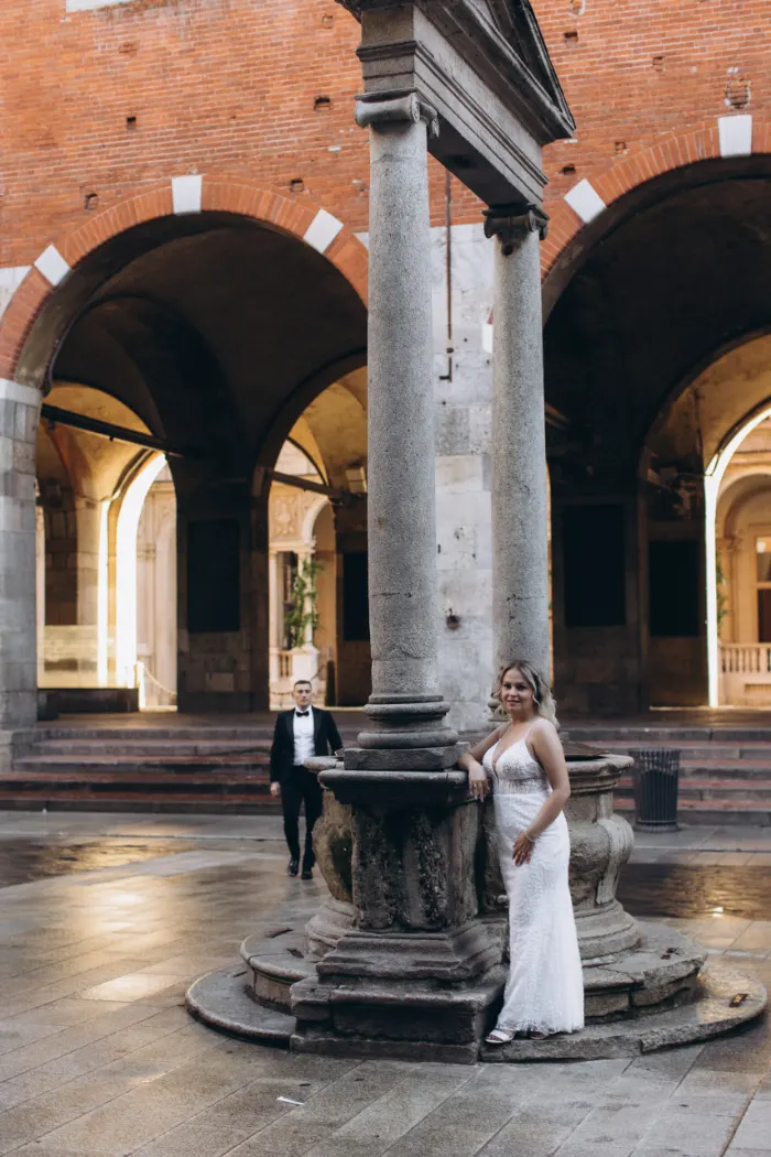 Couple by an old stone well in a Milan courtyard