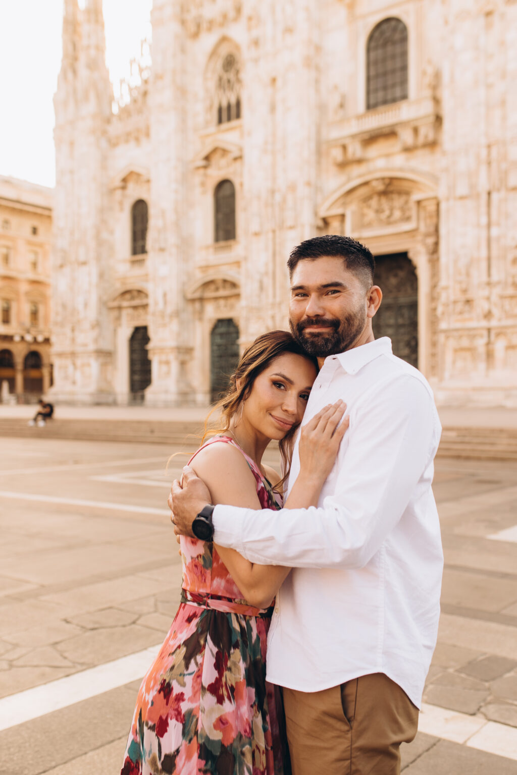 The quinceañera's mother and father embrace in Piazza del Duomo before the Milan Cathedral.