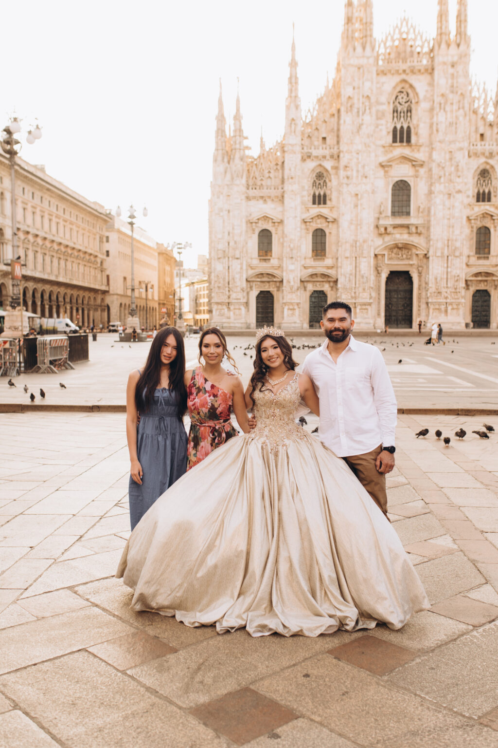 Quinceañera and her family, sister, mother, and father, stand together in Piazza del Duomo before the Milan Cathedral.
