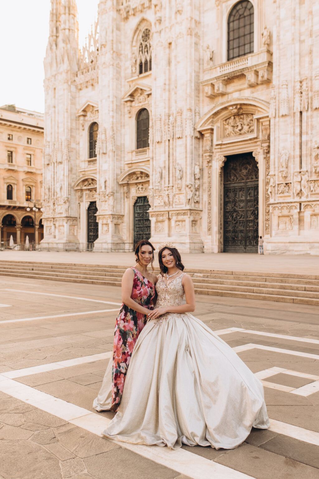 Quinceañera and her mother seated together before the Duomo di Milano in Piazza del Duomo.
