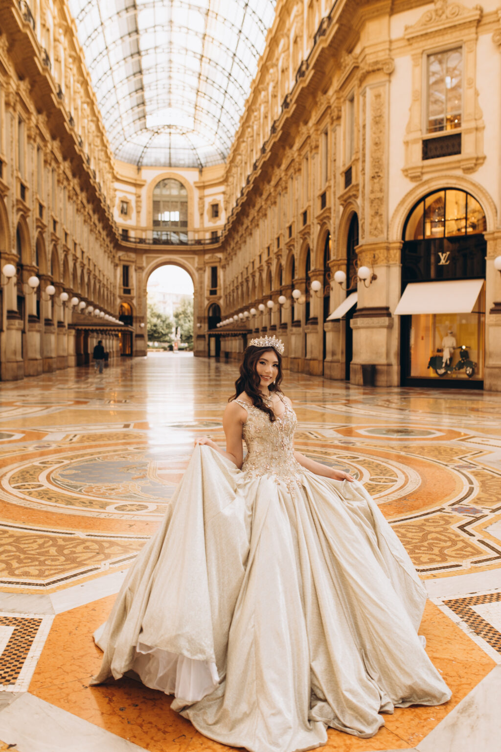 Quinceañera with her gown spread across the central octagon mosaic of the Galleria Vittorio Emanuele II in Milan.