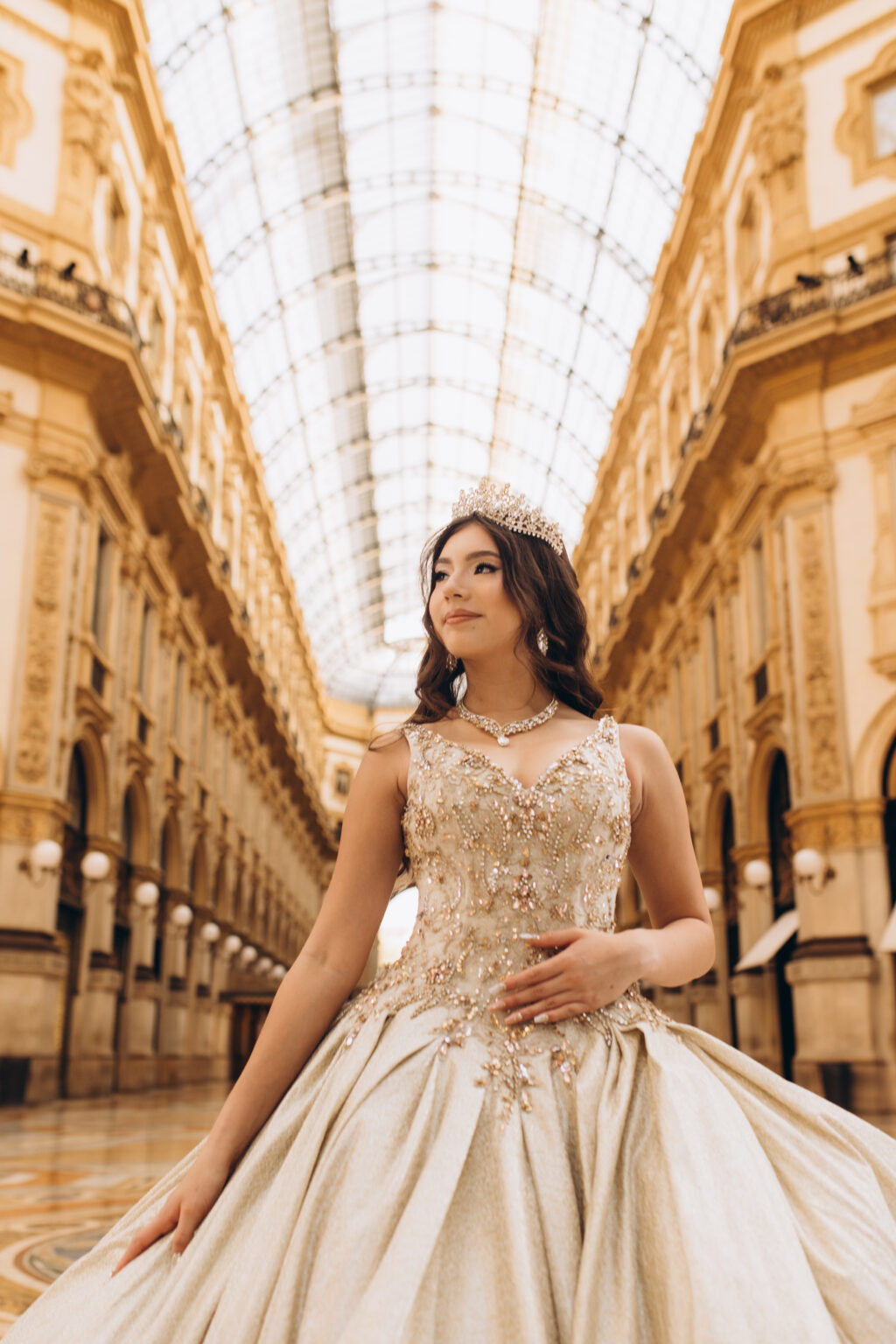 Quinceañera in a crown gazes upward beneath the glass barrel vault of the Galleria Vittorio Emanuele II in Milan.