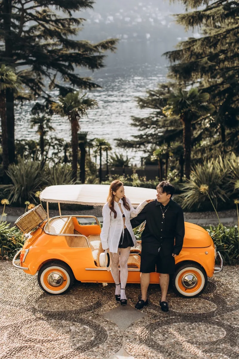 Couple with an orange Fiat 500 in the gardens of Villa Cipressi, Varenna
