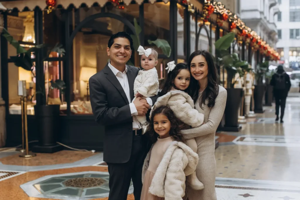 Family with three young children by a festive shop window in Milan
