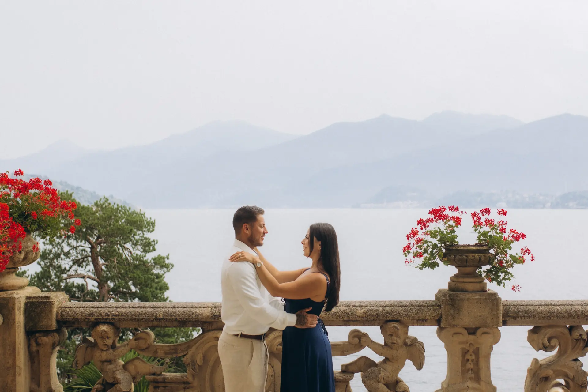 Couple embracing on the balustrade terrace of Villa del Balbianello above Lake Como